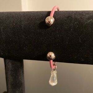 Pink and golden bangle with clear bead charm